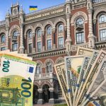 Національний банк України з купюрами долара та євро на передньому плані
