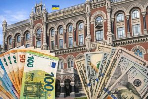 Національний банк України з купюрами долара та євро на передньому плані
