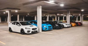 Ряд тюнінгованих спортивних автомобілів у підземному паркінгу вночі