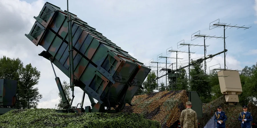 Піднята пускова установка Patriot під маскувальною сіткою з антенами та військовими